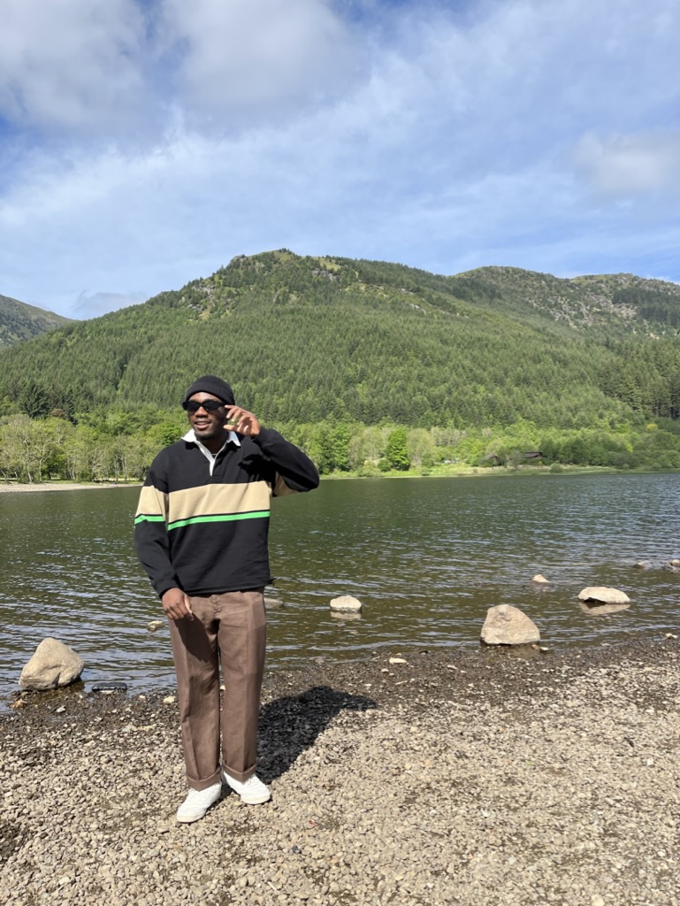 Ayo standing behind a mountain overlook in Scotland